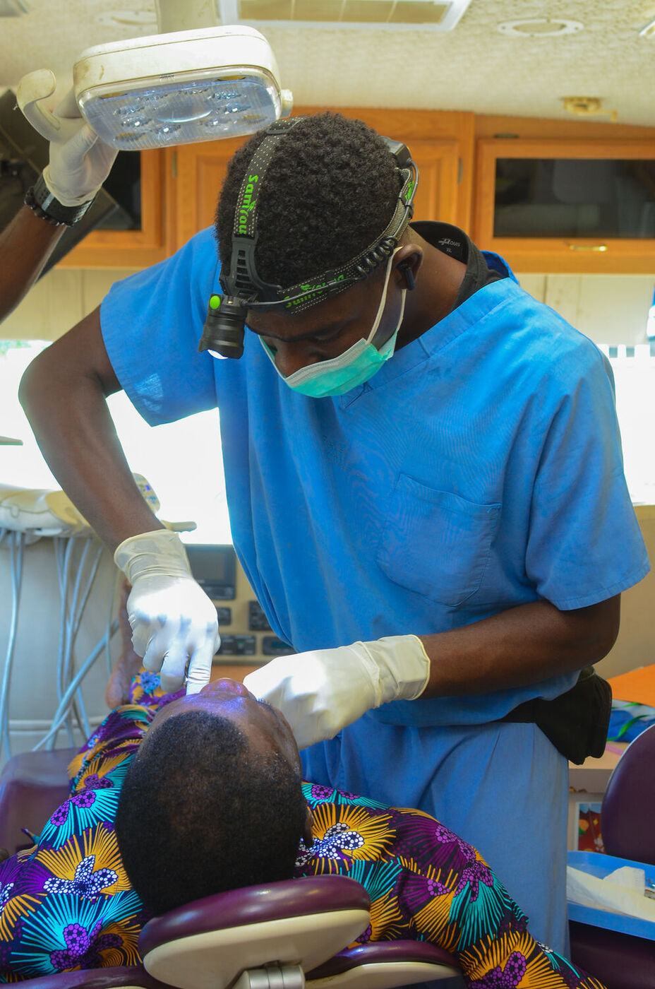 A volunteer dentist caring for a patient at an outreach