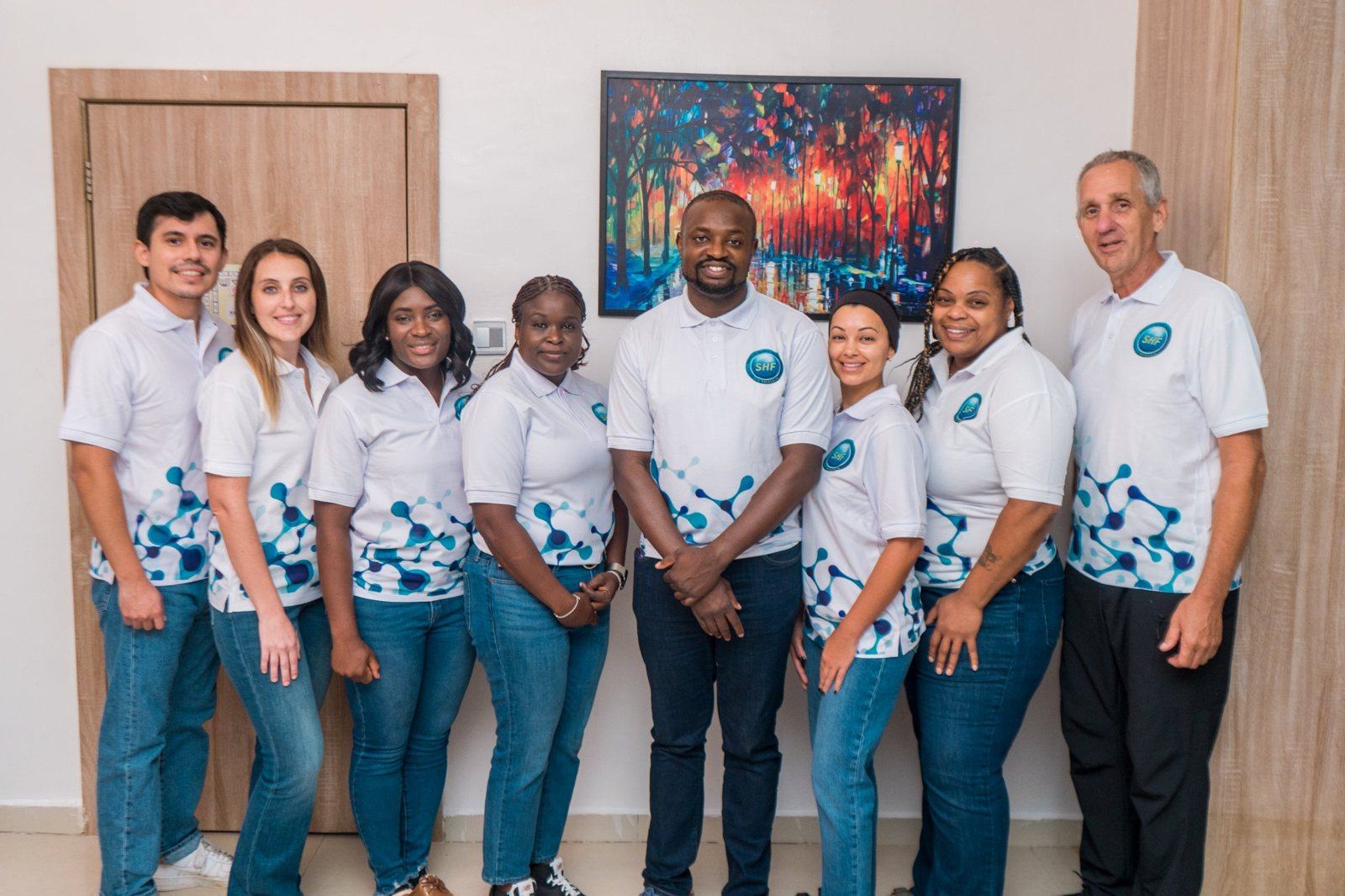 Dr. Adeboye with eight members of the Shekinah Global Healthcare Foundation team in matching SHF shirts